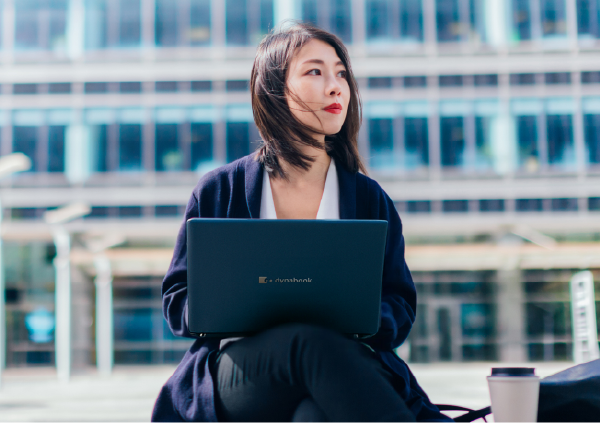 外でノートPCで仕事をする人物