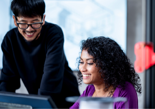 笑顔で談笑しながら仕事をする二人の人物