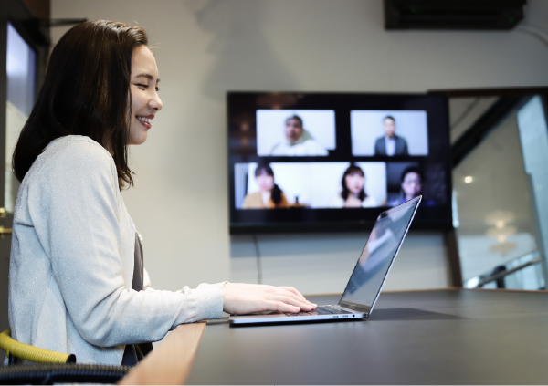 会議室でオンラインミーティングをする人物